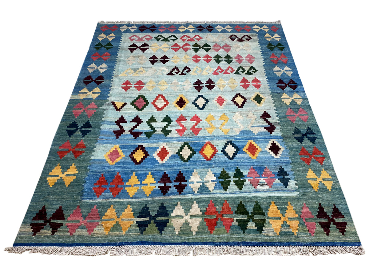Blue kilim rug shown in full, with multicolored rows of crosses and diamonds, fringes