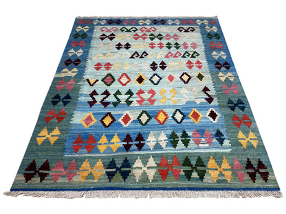 Blue kilim rug shown in full, with multicolored rows of crosses and diamonds, fringes