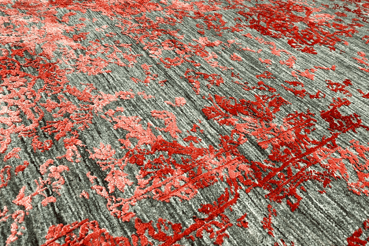 Detailed view of the carpet pattern in red and gray with subtle, relief-like color gradients