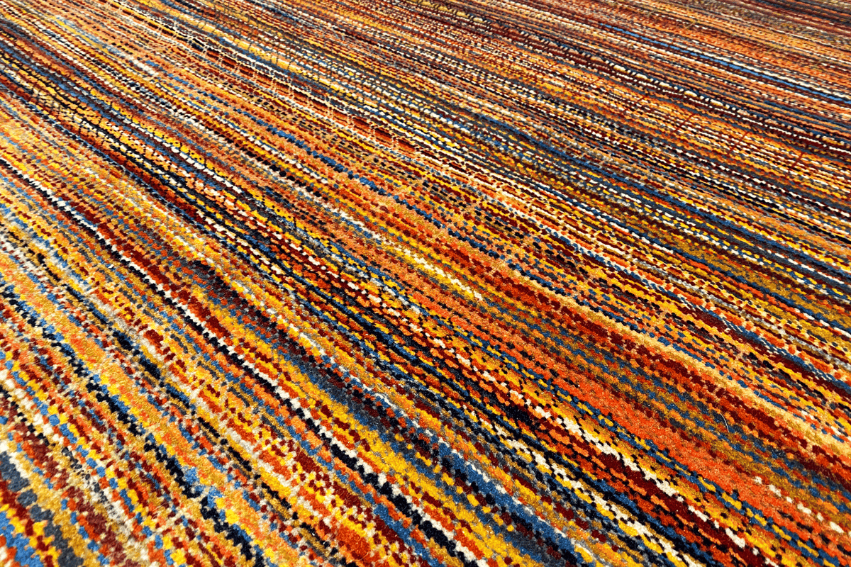 Carpet surface with a dense pattern of orange, blue, and brown lines