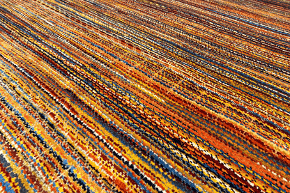 Carpet surface with a dense pattern of orange, blue, and brown lines