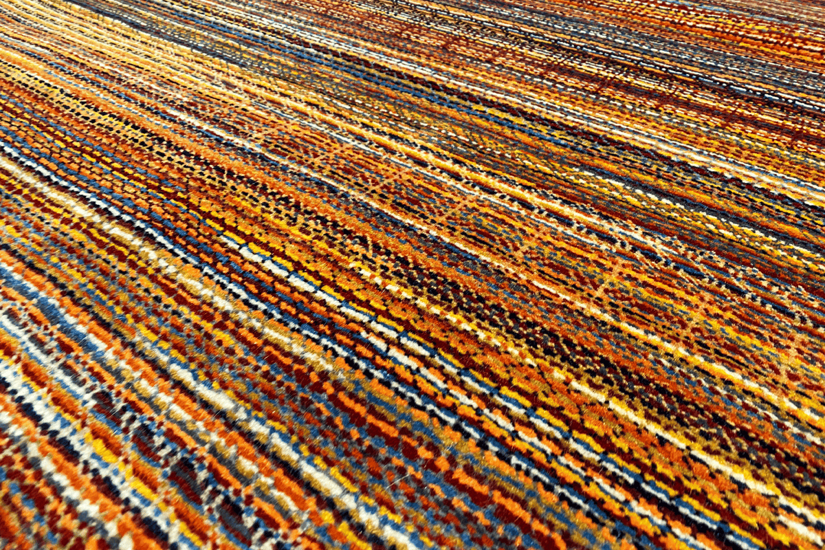 Close-up: multicolored lines in the wool rug with fine contrasting stripes