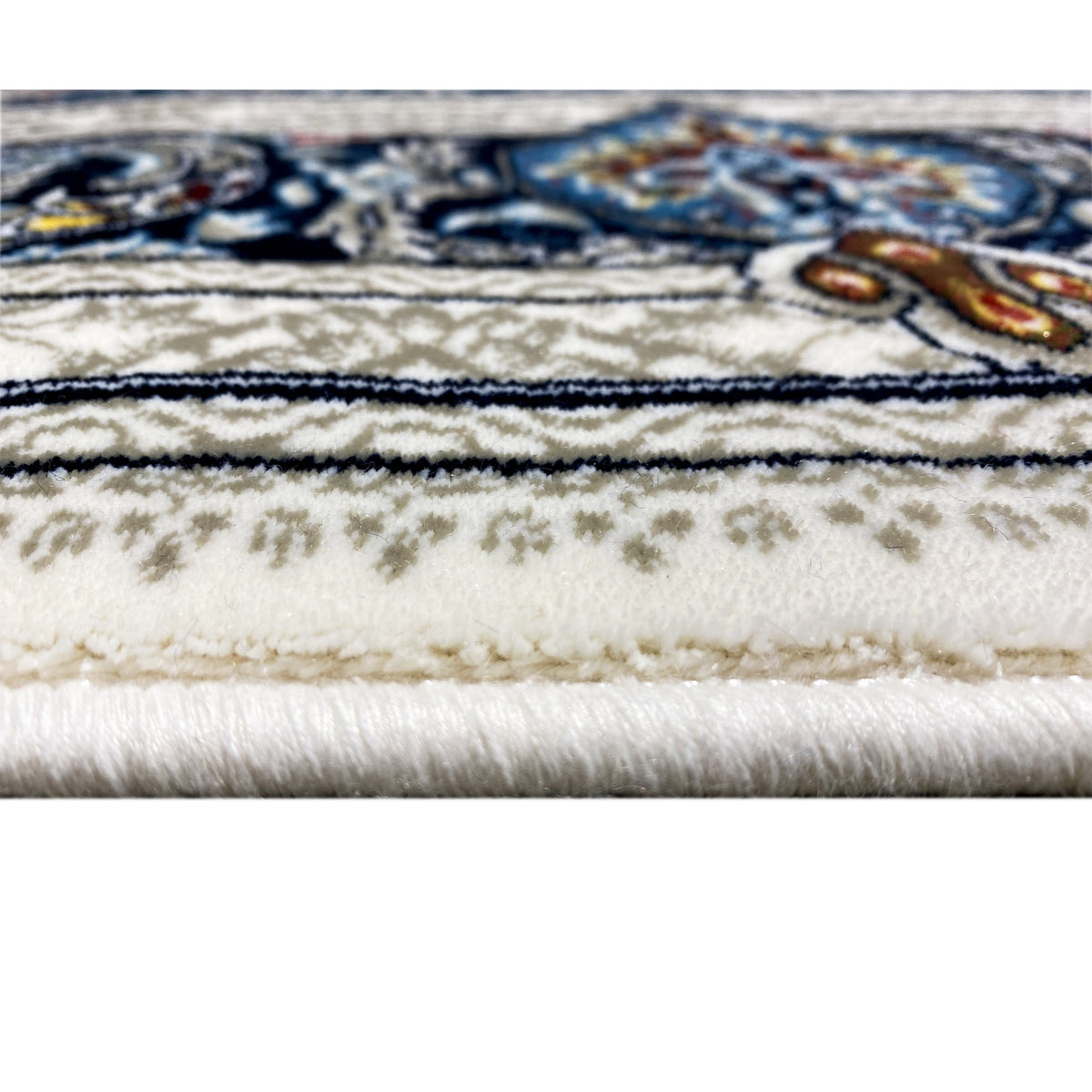 Close-up: fringe and edge of a cream-colored Oriental rug with a blue detailed border