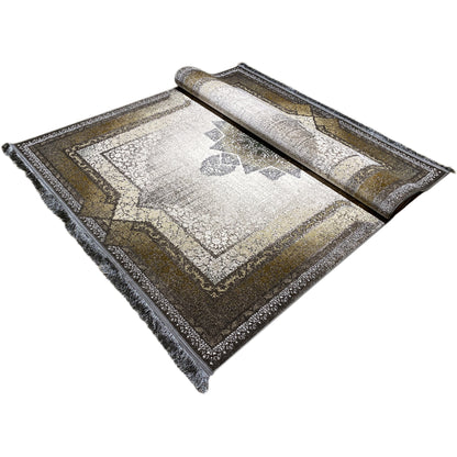Rolled carpet with a visible ornamental surface and surrounding border in light, dark, and gold tones