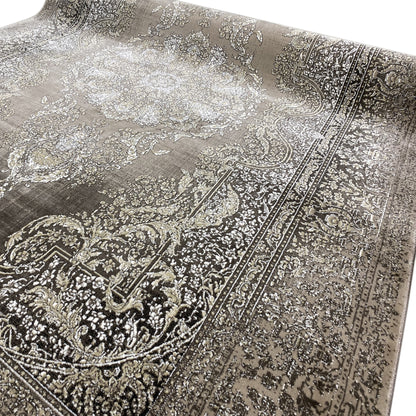 Close-up: medallion and decorative ornaments, silver-gray pattern on a dark carpet