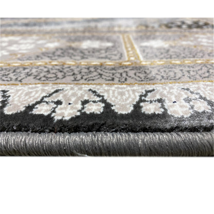 Close-up: rug edge with pile texture and fringe, patterned border in gray and gold