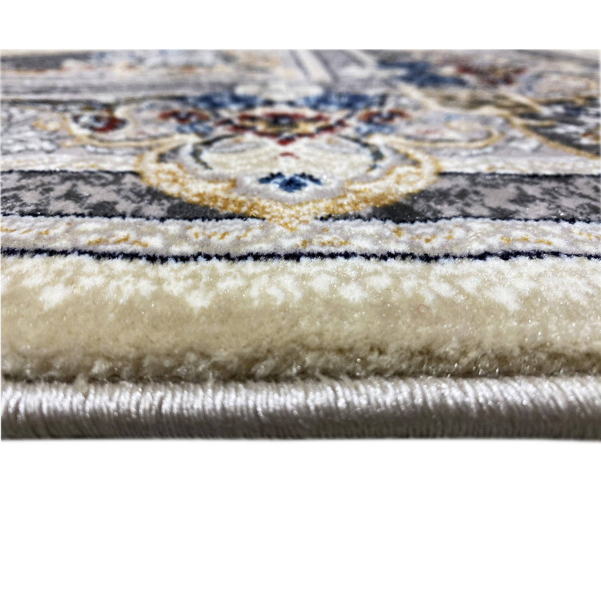 Carpet detail with a floral border in beige, blue, and dark blue, as well as fringes