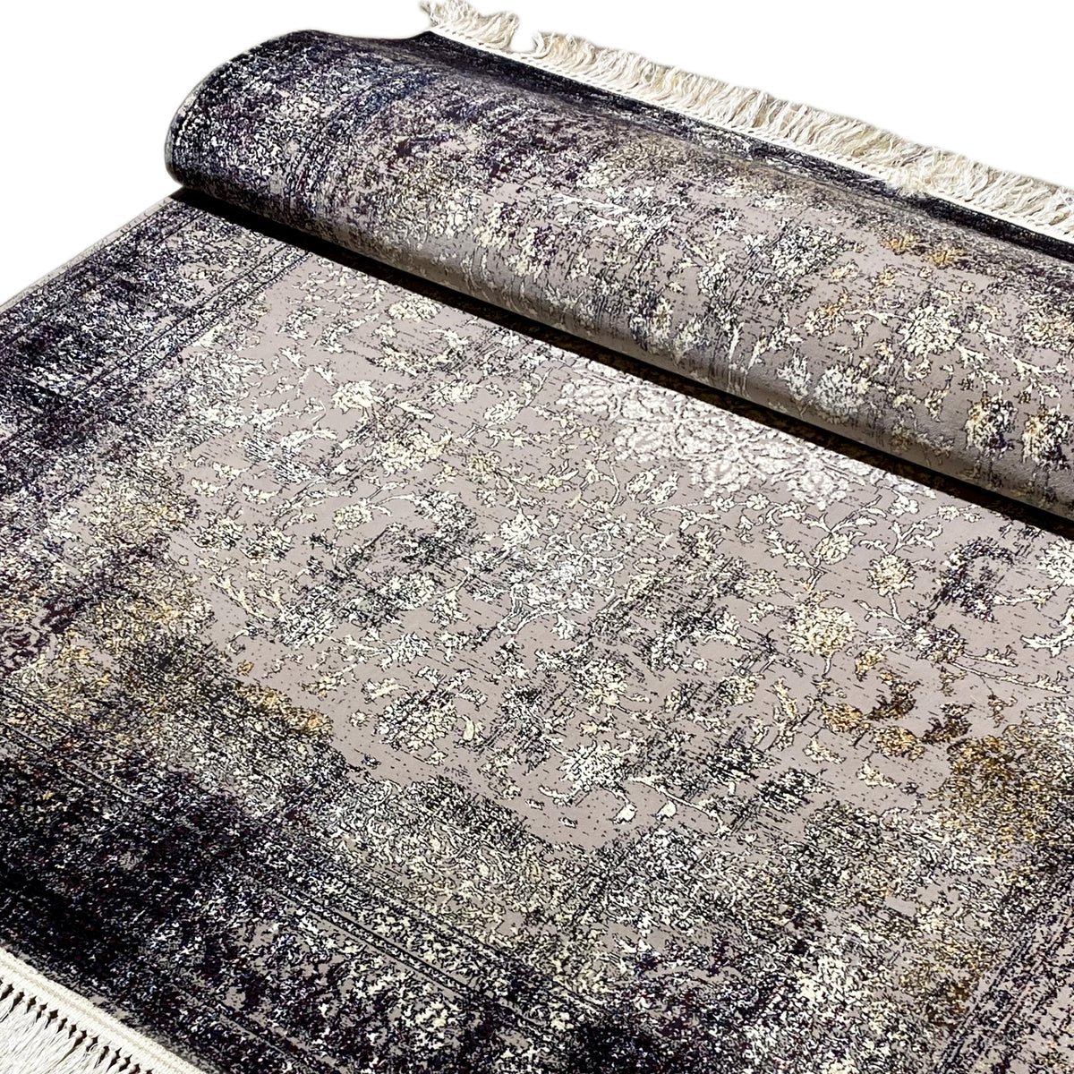 Rolled-up vintage rug with an ornamental pattern in gray, beige fringed edge at the top