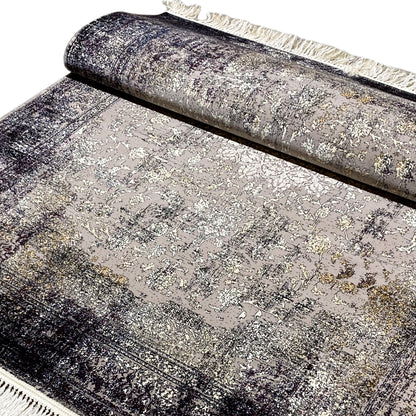 Rolled-up vintage rug with an ornamental pattern in gray, beige fringed edge at the top