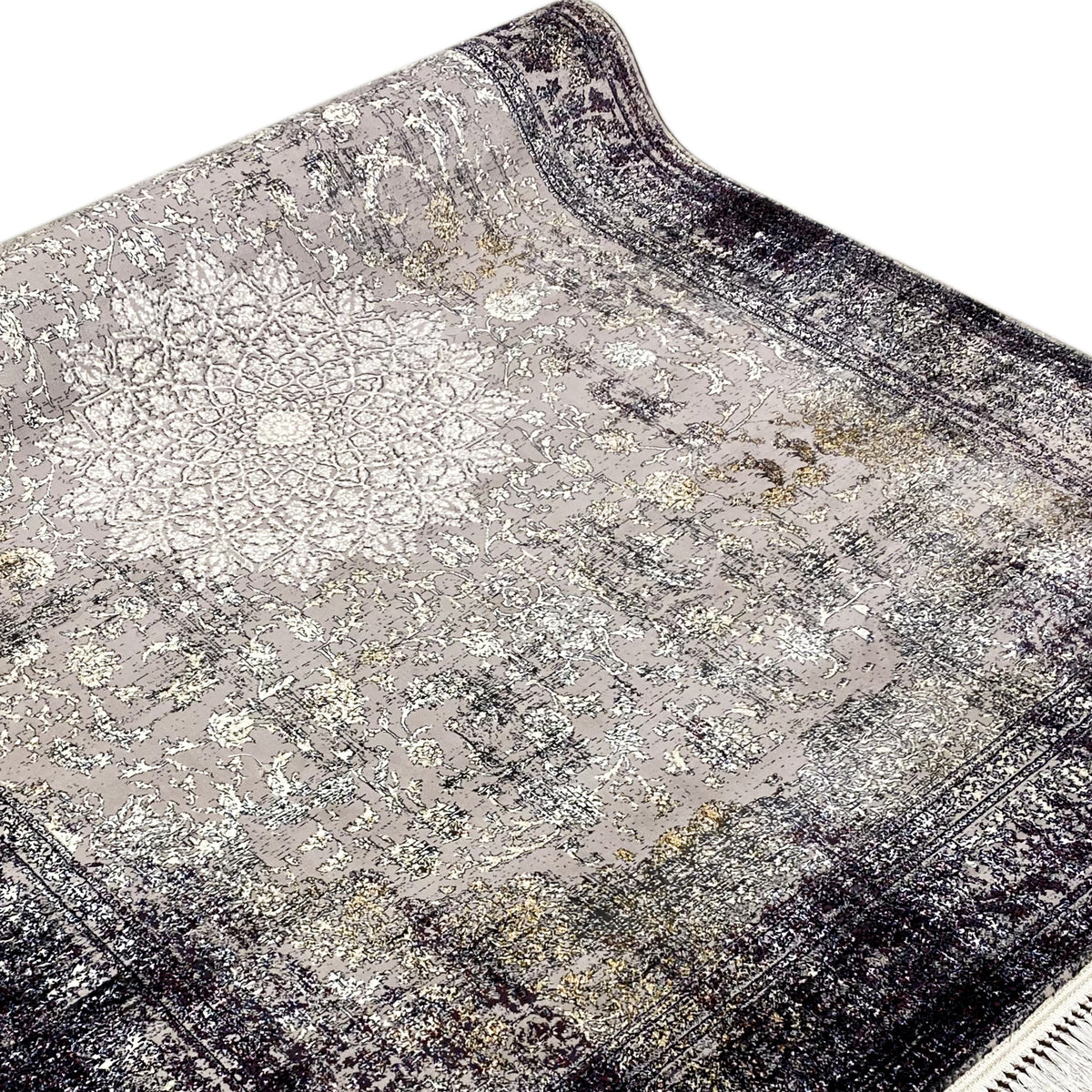 Close-up: vintage rug with an ornament/tile pattern, gray-beige surface, dark border, and fringe