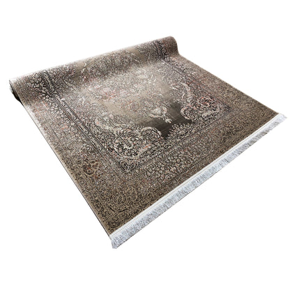 Oriental rug with a silver-gray background and dark ornamental pattern, rolled up