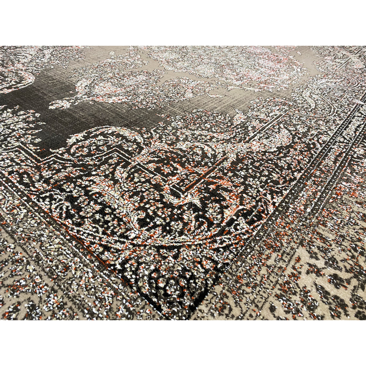 Close-up of the carpet pattern: silver-gray and dark ornaments with small touches of color