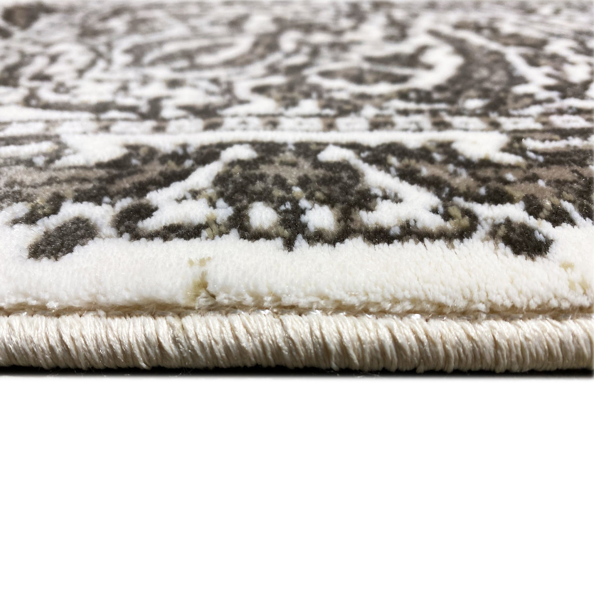 Carpet detail with pile height and bound edge, cream-and-silver pattern