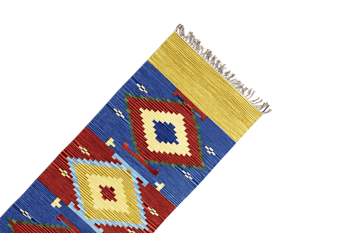 Kilim-dhurrie rug detail: yellow edge with fringe and a blue diamond pattern
