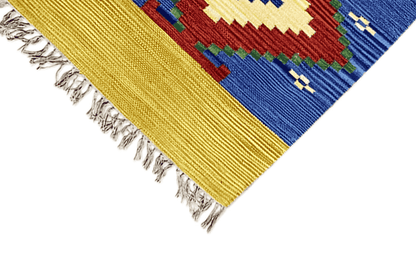 Kelim Dhurrie rug corner view: yellow border, fringes, blue square motif