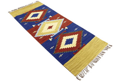 Wool kilim runner with a geometric pattern and yellow border in blue, red, and cream, with fringes