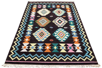 Kilim rug with a geometric tribal pattern on a dark background, colorful accents, and fringes
