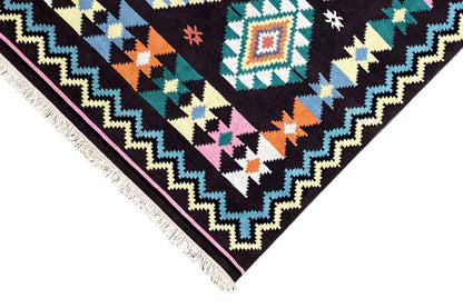Kilim rug corner with a zigzag border, colorful triangles, and fringes along the edge