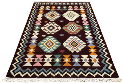 Wool kilim rug with a geometric pattern, colorful diamonds, and fringes along the edge