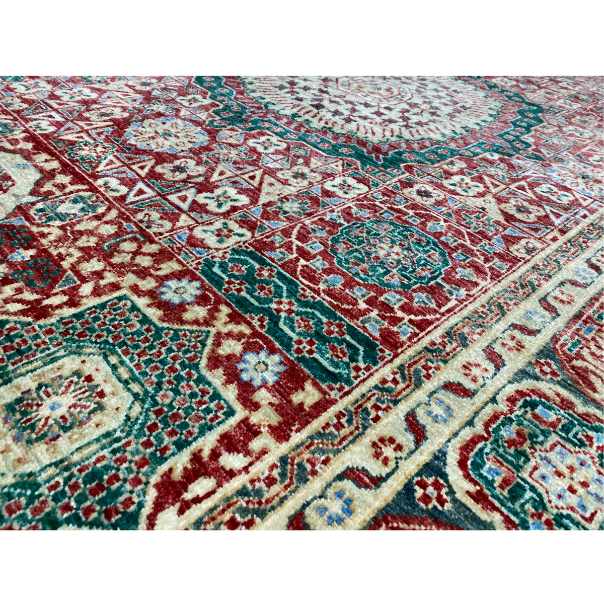 Close-up of a red Mamluk rug: dense pattern in red, turquoise, and cream