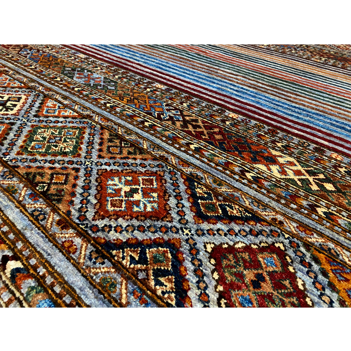 Close-up: colorful Khorjin rug with intricate diamonds, ornaments, and a fringed border