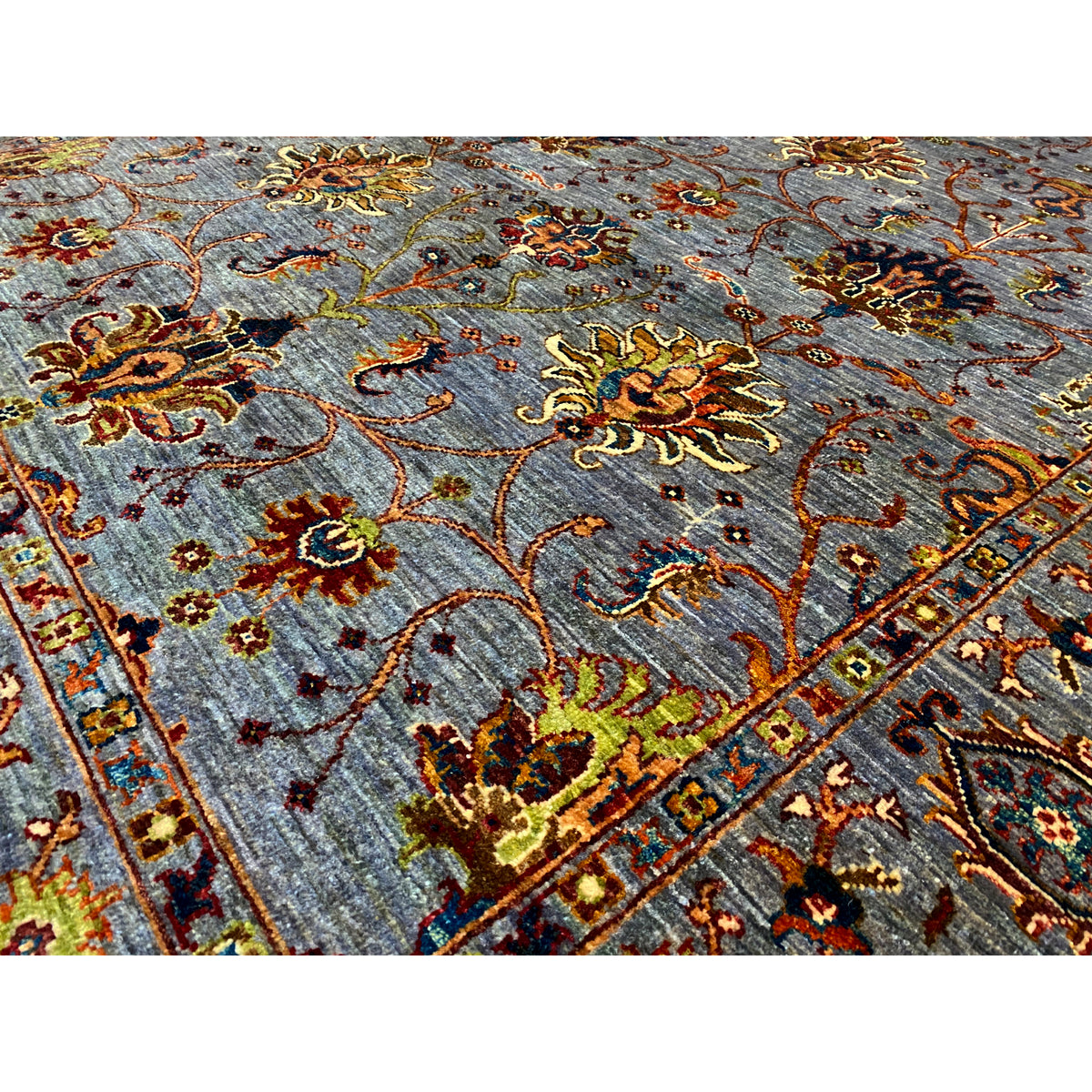 Close-up: gray Oriental rug with colorful floral ornaments