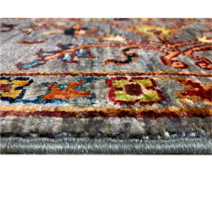 Close-up of the carpet edge: gray Oriental rug with fringe and woven texture