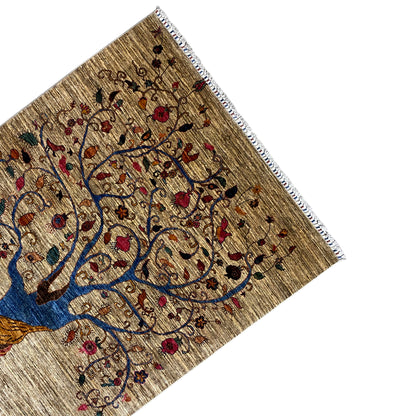Corner of the beige Khorjin rug with a blue tree and colorful embroidery