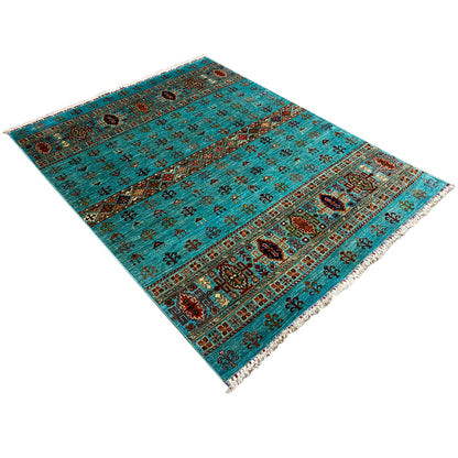 Turquoise khorjin rug spread diagonally, with detailed ornaments and fringes