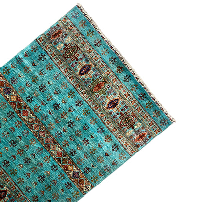 Turquoise carpet with border stripes, side view and fringes along the edge