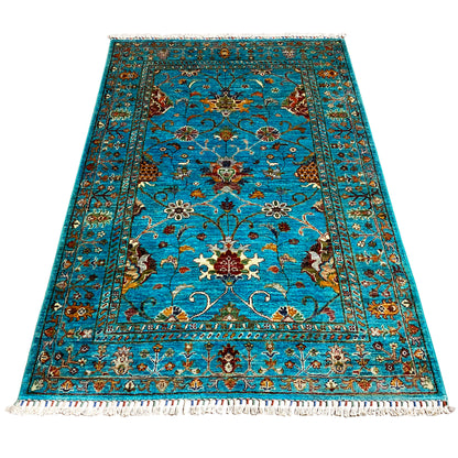 Turquoise Khorjin rug with a large pattern and medallion, fringes along the edge