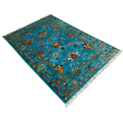 Turquoise Khorjin rug in diagonal view, patterned border, fringes