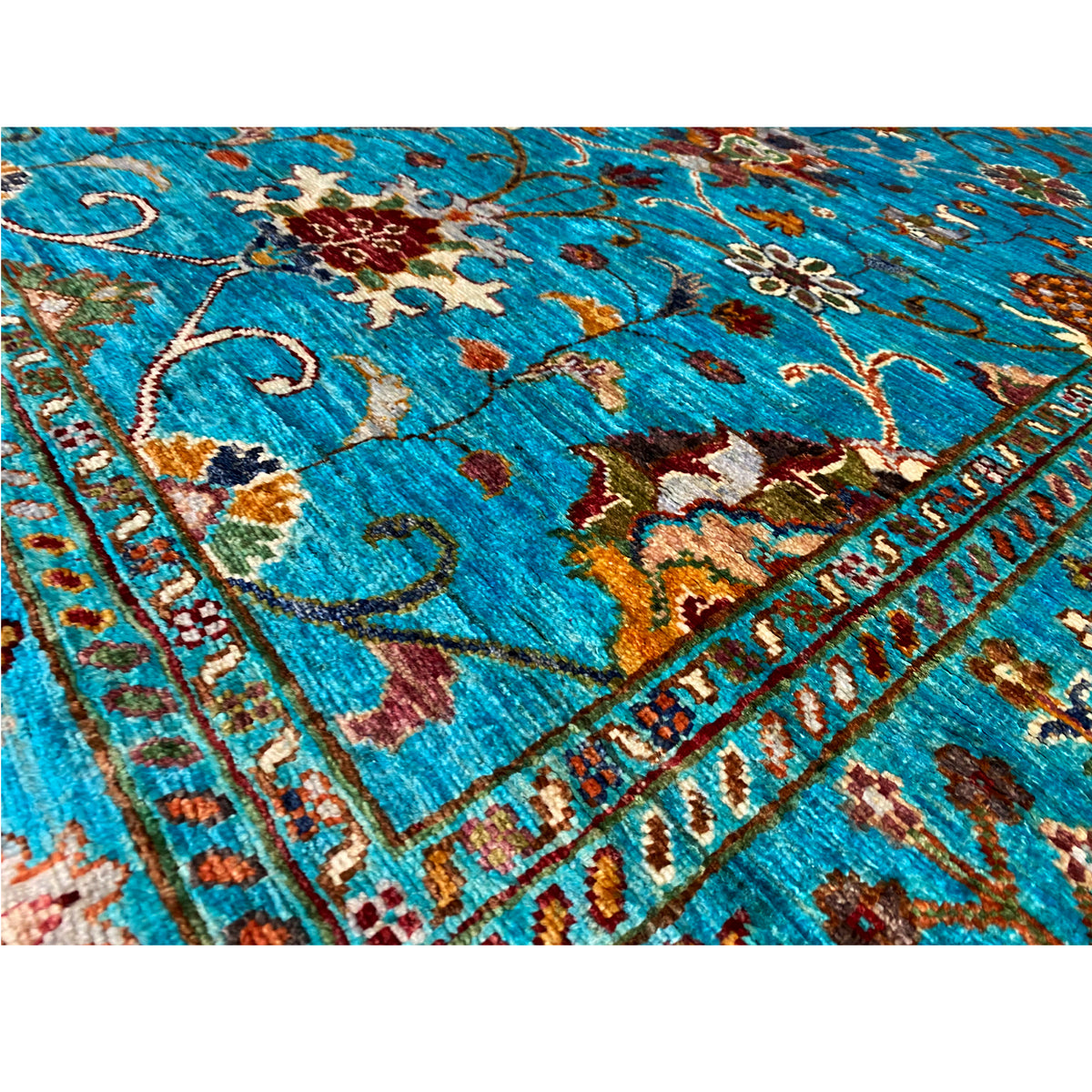 Close-up: Turquoise Khorjin rug with floral ornaments and colorful details