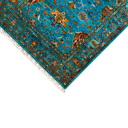 Corner of the turquoise Khorjin rug with borders and fringe along the edge