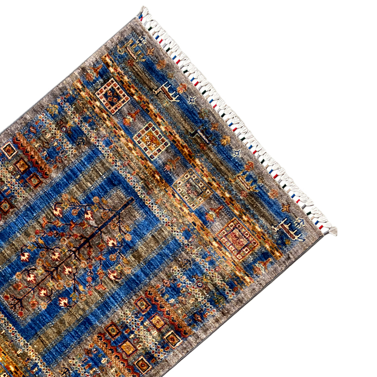 Corner view: blue-brown Khorjin rug with medallion design and white fringed edge