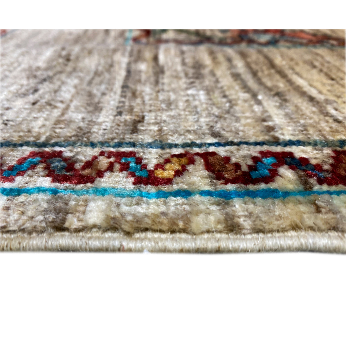 Detail of a Khorjin rug edge: beige background with blue trim and fringes