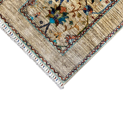 Close-up detail of Khorjin rug: beige rug fabric with a colorful border and white fringed edge