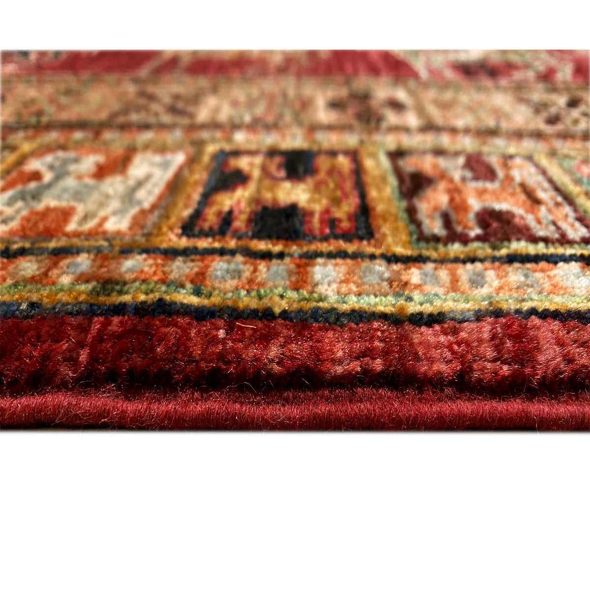 Close-up of the carpet edge with red pile and colorful pattern elements