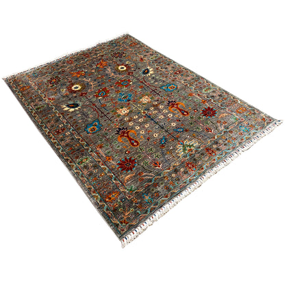 Gray Khorjin rug viewed diagonally; multicolored ornamental pattern and bound edges