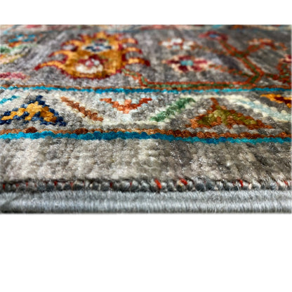 Detail at the edge: gray carpet pile surface with a colored border and short fringes