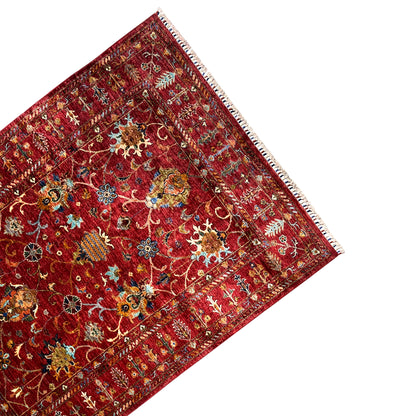 Red Khorjin rug corner view, border and ornament panel, fringe along the edge