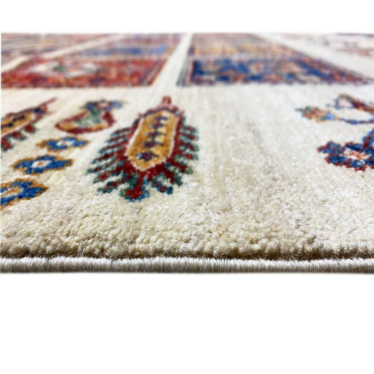 Wool rug detail: dense pile on a light background with a tile pattern in the crop