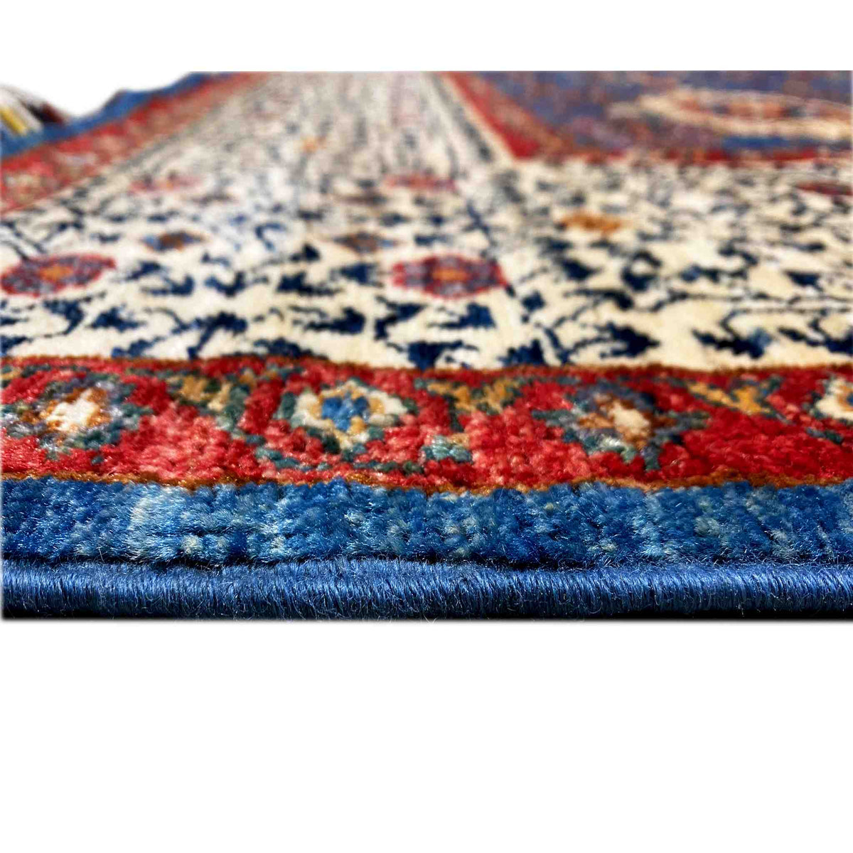 Ziegler carpet close-up: blue border with a red stripe and colorful pattern