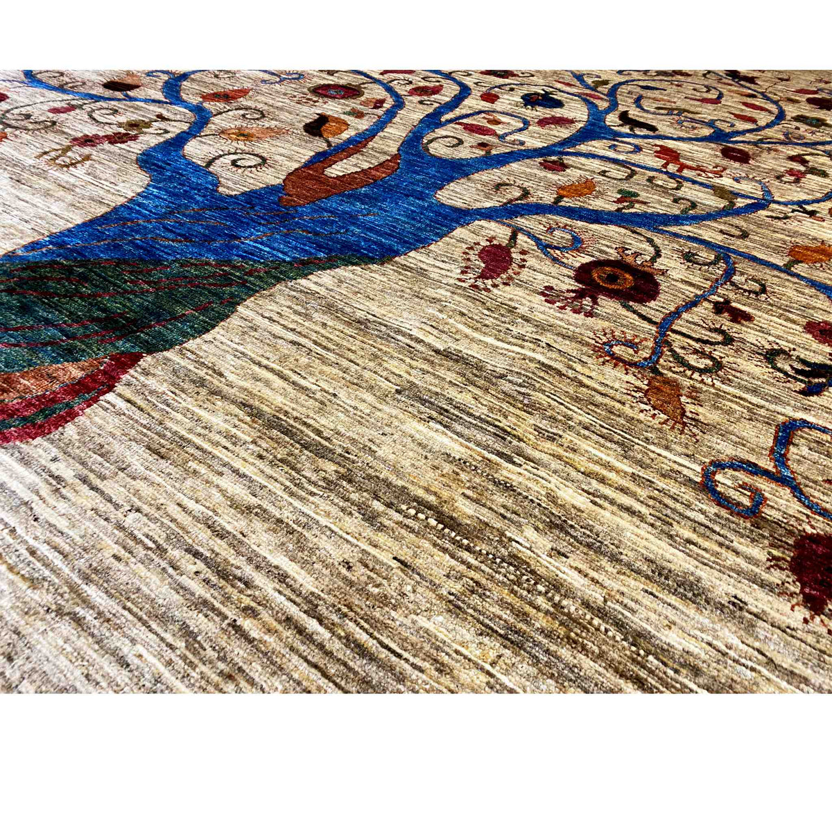 Close-up of a carpet: blue tree and colorful ornaments on a beige background