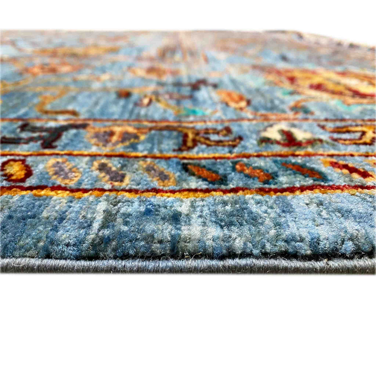 Close-up: blue rug with a multicolored pattern and visible pile height