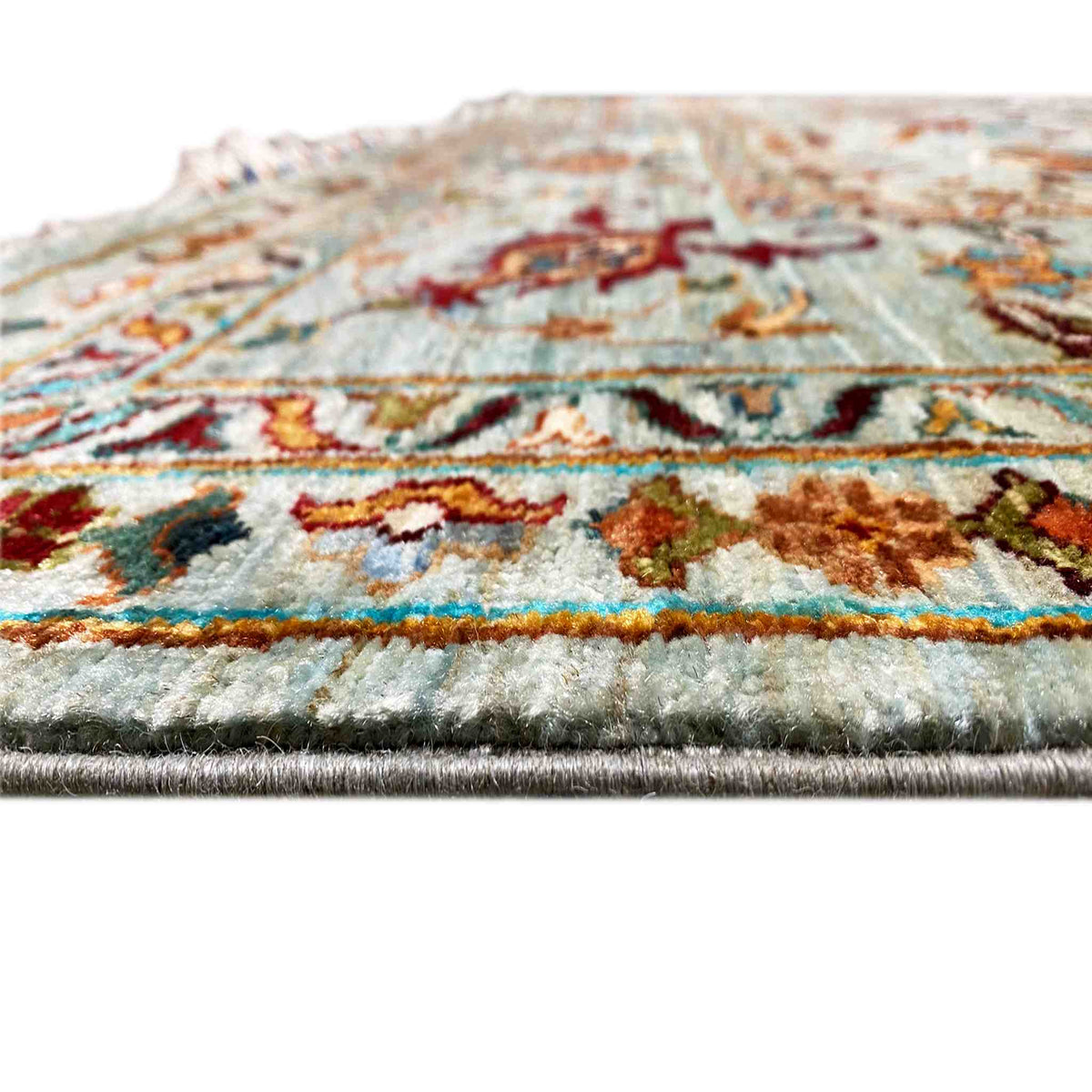 Close-up of a carpet edge with a multicolored pattern and woven pile