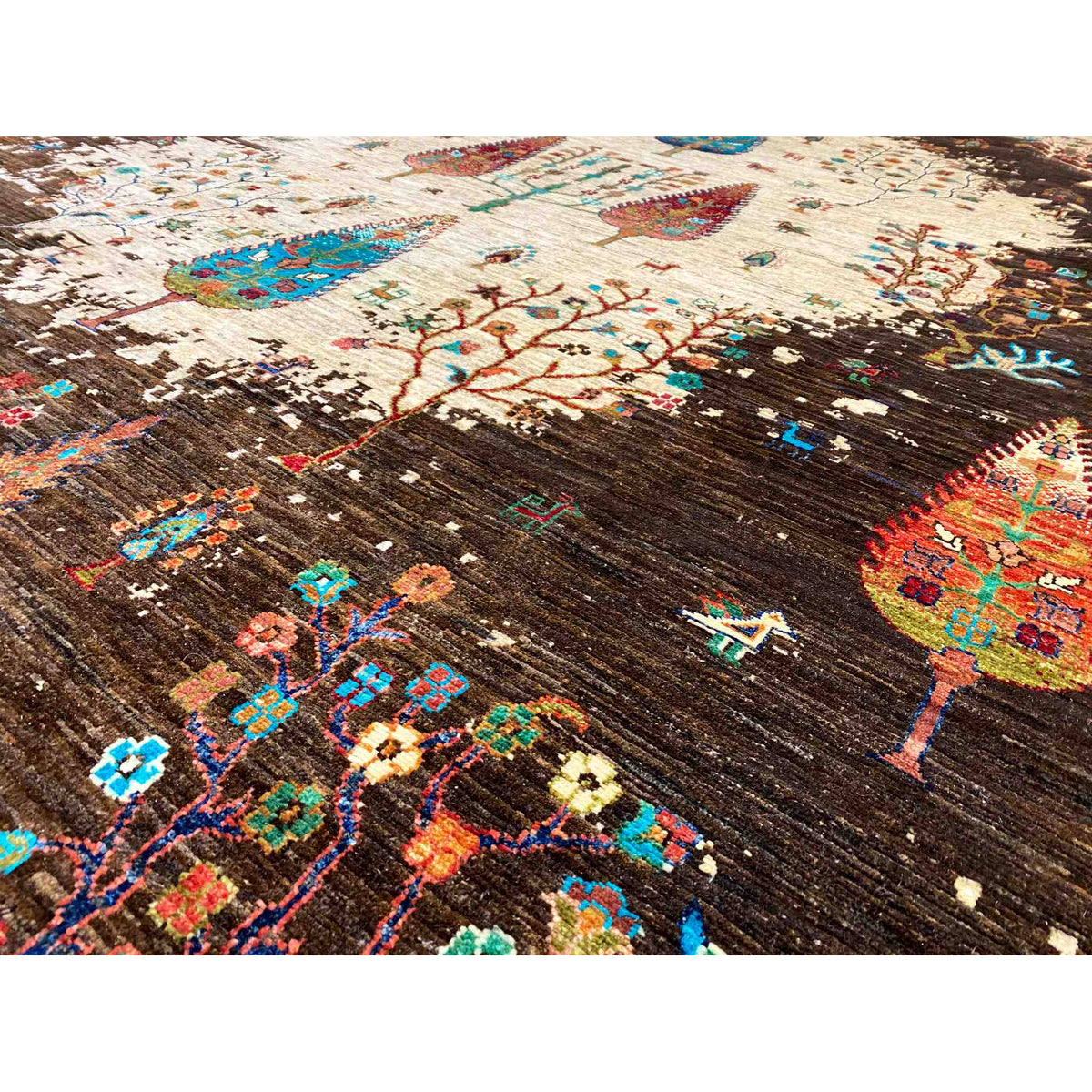 Close-up: dark brown carpet surface with cream-colored ornaments and colorful crosses/figures