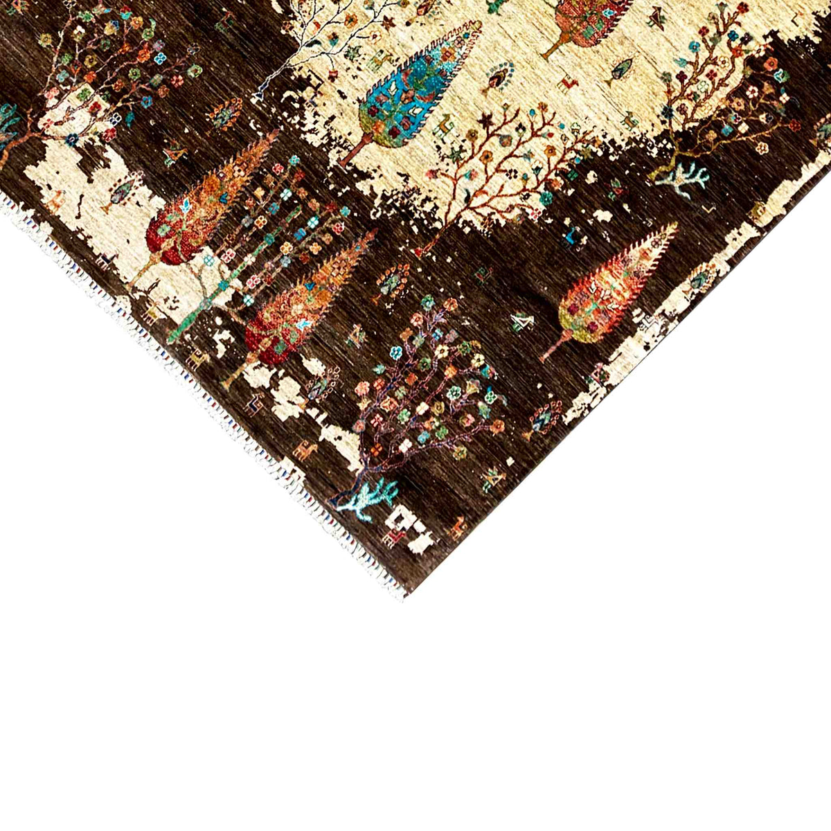 Carpet corner in detail: fringed edge, dark brown background, and cream-colored patterns with colorful motifs