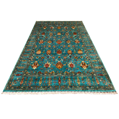 Rectangular rug with a decorative ornamental pattern in turquoise, gold, and red, with fringes