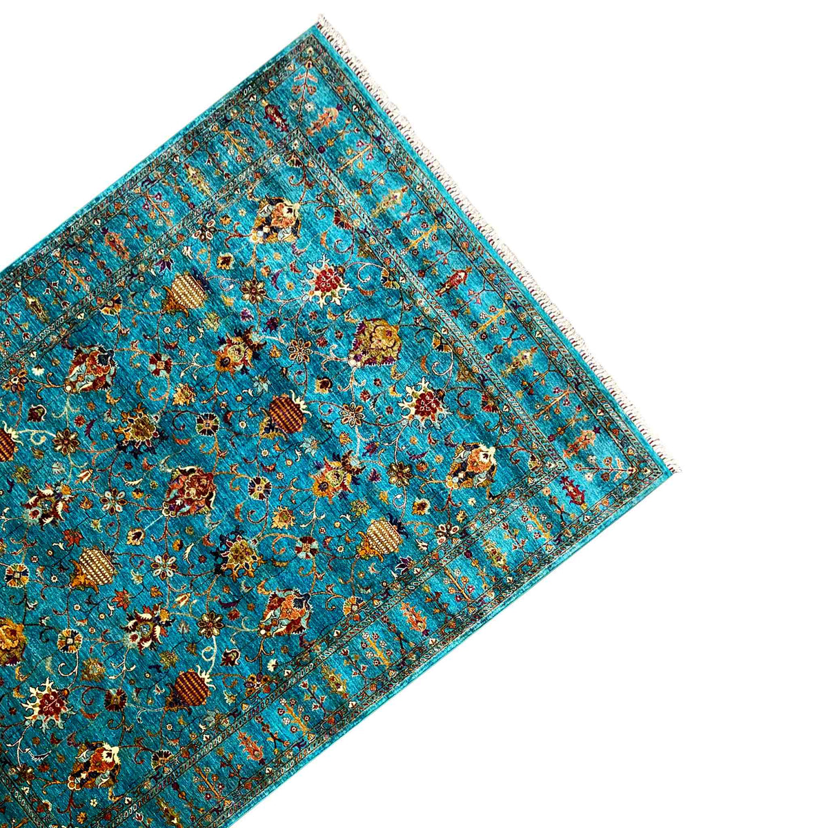 Turquoise rug with a colorful ornamental pattern, angled view and fringes